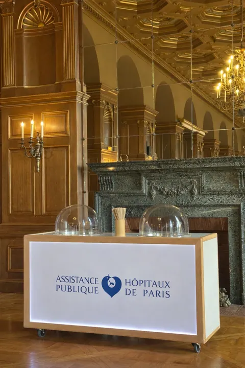 Stand AP-HP devant une cheminée en marbre